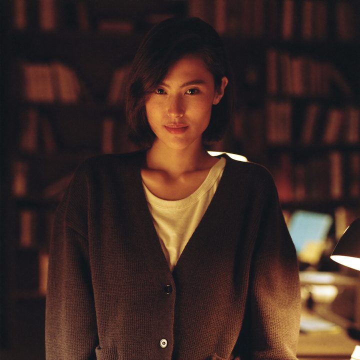 Juno between the shelves of a bookshop at night