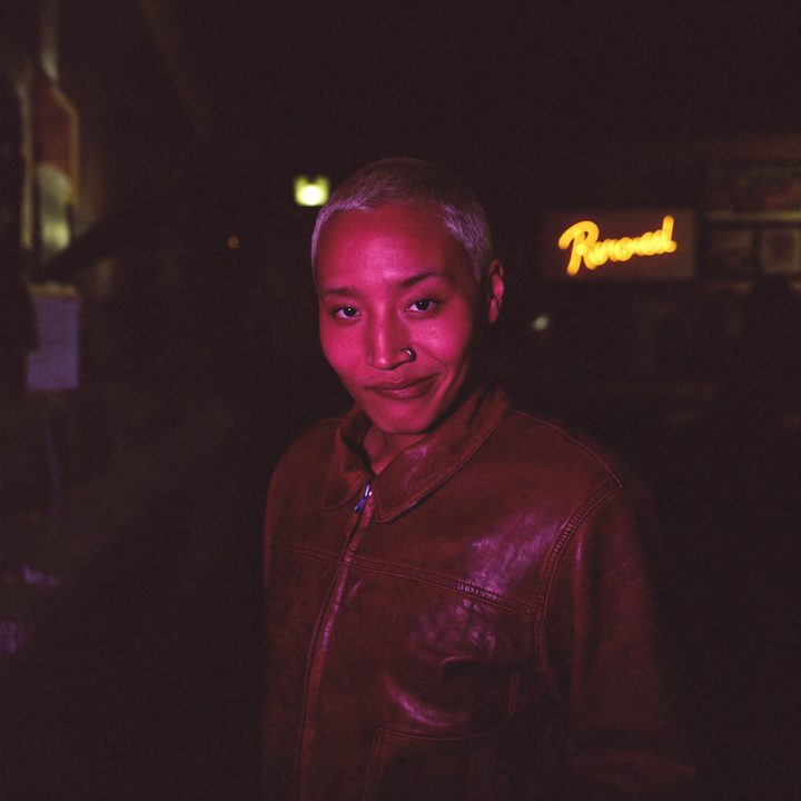 Kit in a neon-lit record shop