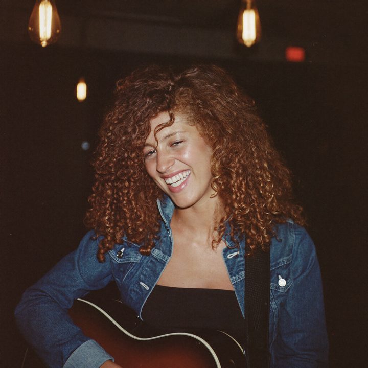 Saffi laughing backstage with her guitar